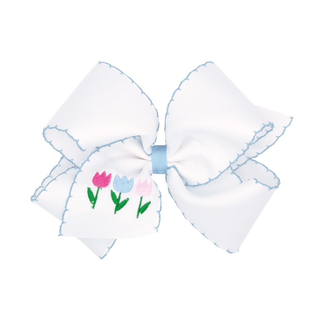 Large white bow with embroidered tulips on a white background