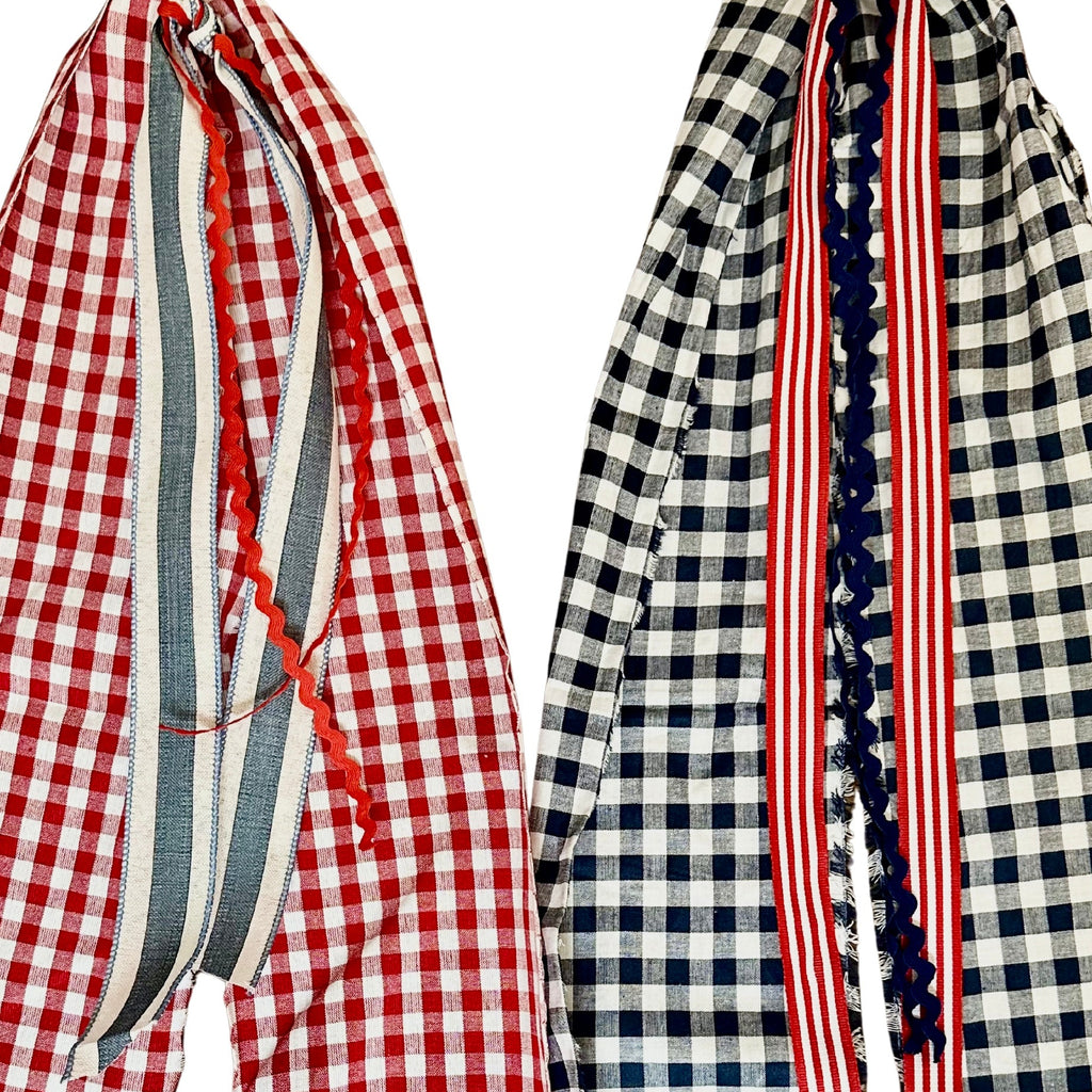 Two gingham scarves, one red and white, the other black and white, with a striped pattern.