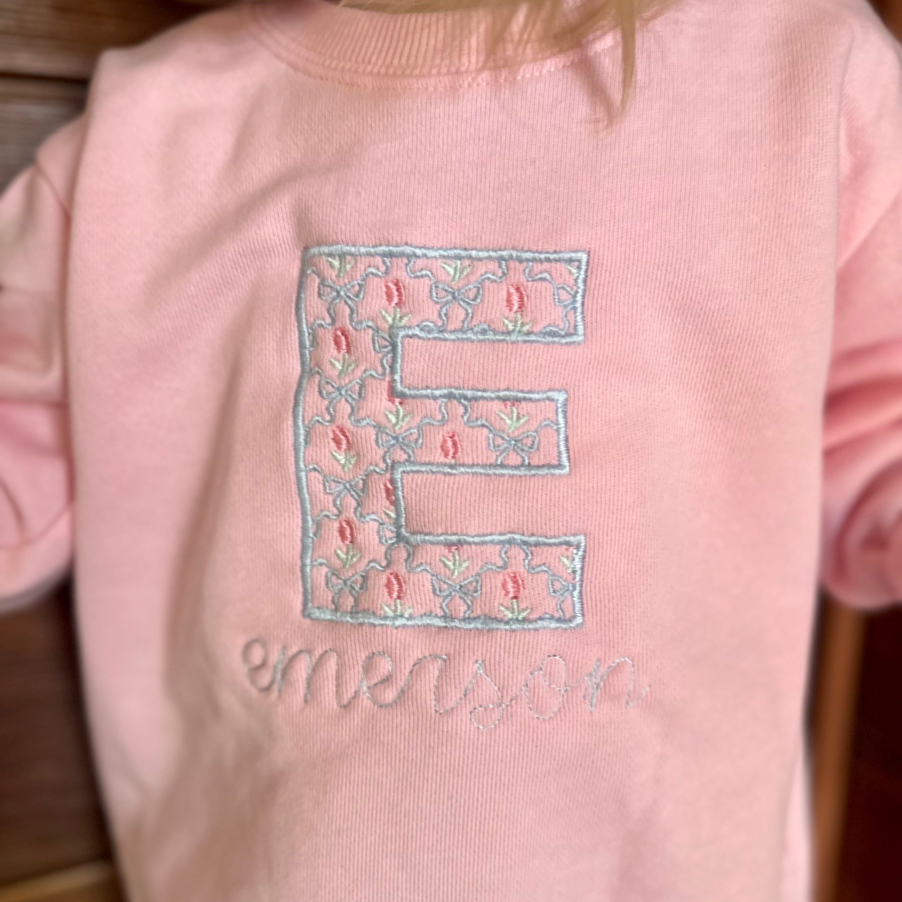 Floral E embroidered on a pink sweatshirt for little girl