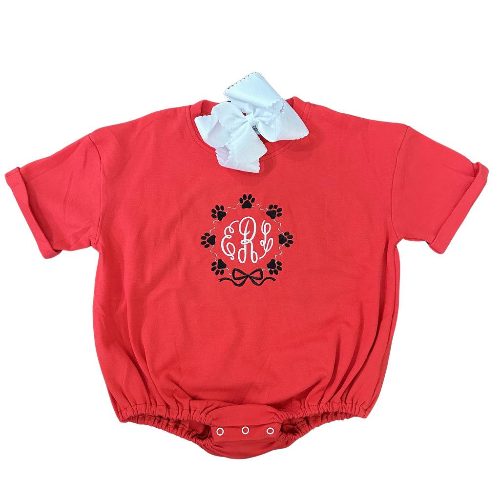 Red baby romper with monogram and paw prints on a white background